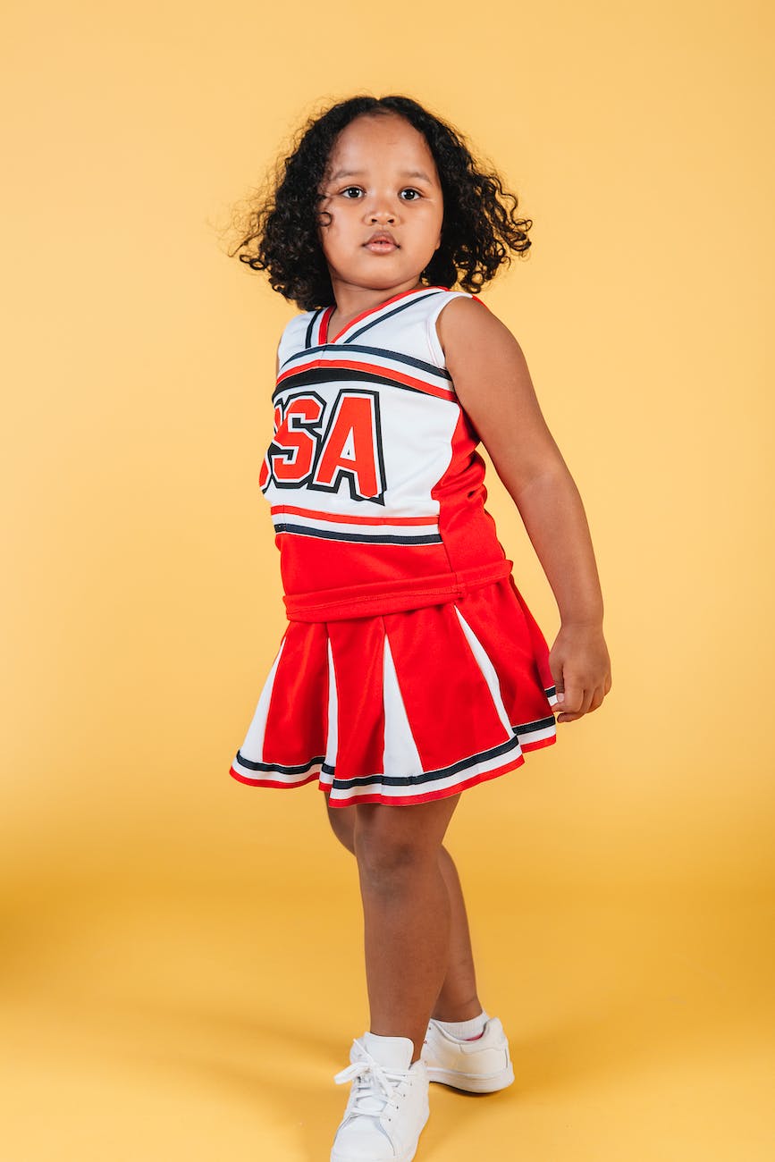 confident african american female kid in cheerleader uniform in studio